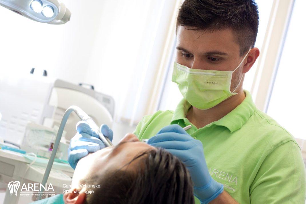 Doktor popravlja zub pacijentu.