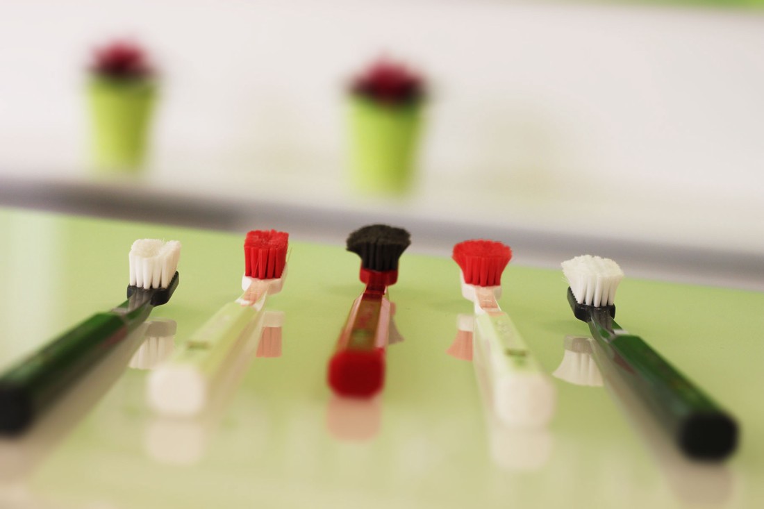 Na stolu postavljene različite vrste četkica za zube.