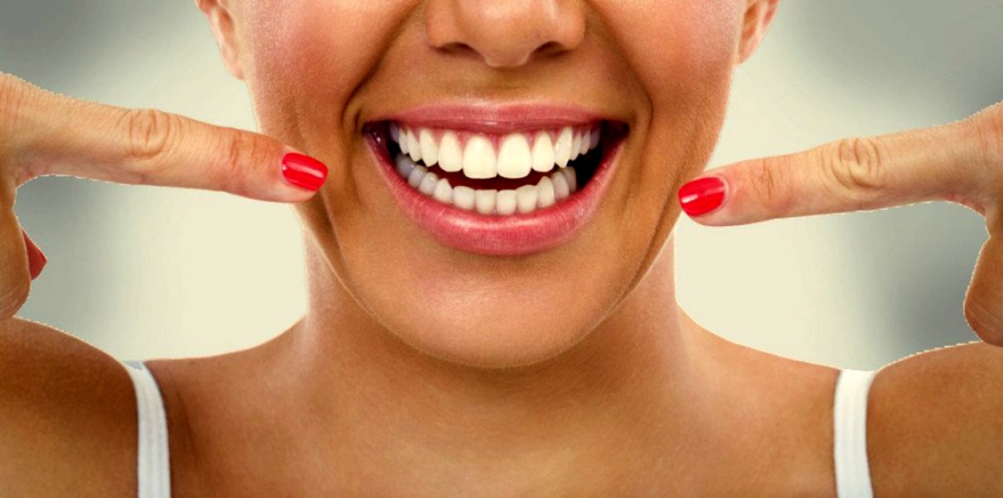 Žena pokazauje svoj bijeli osmijeh.