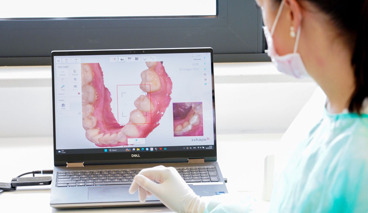 Doktorica u kirurškoj opremi pažljivo proučava 3D sken čeljusti na računalnom ekranu, pripremajući se za zahvat.