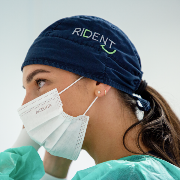 Doktor stavlja zaštitnu masku na lice u sklopu pripreme za stomatološki kirurški zahvat u sterilnim uvjetima ordinacije.