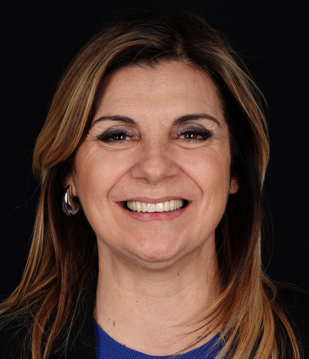 Portret pacijentice nakon implantološke terapije i estetske rekonstrukcije s cirkonskim krunicama, s prirodnim i osvježenim izgledom lica te obnovljenim osmijehom.