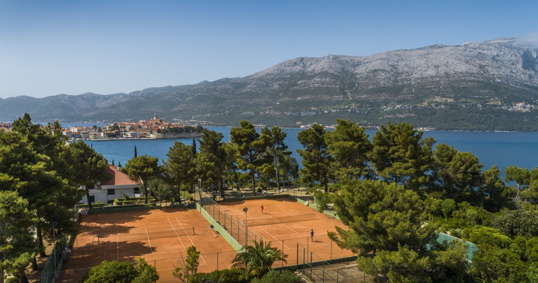 Due campi da tennis all'aperto con una vista mozzafiato sul Mare Adriatico, le montagne e la storica città di Korcula presso l'Aminess Younique Liburna Hotel.