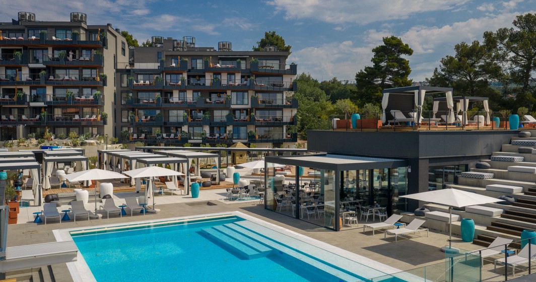 Vanjski infinity bazen s terasama i modernim lounge prostorom u resort okruženju s pogledom na more