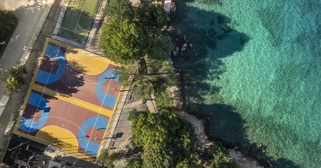 Sports zone with a tennis court and green surroundings at Aminess Style Camping Atea Resort.