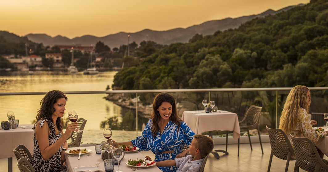 Gosti uživaju u obroku na terasi restorana, s prekrasnim pogledom na zalazak sunca unutar resorta, blizu Port9 Planet Camping by Aminess.