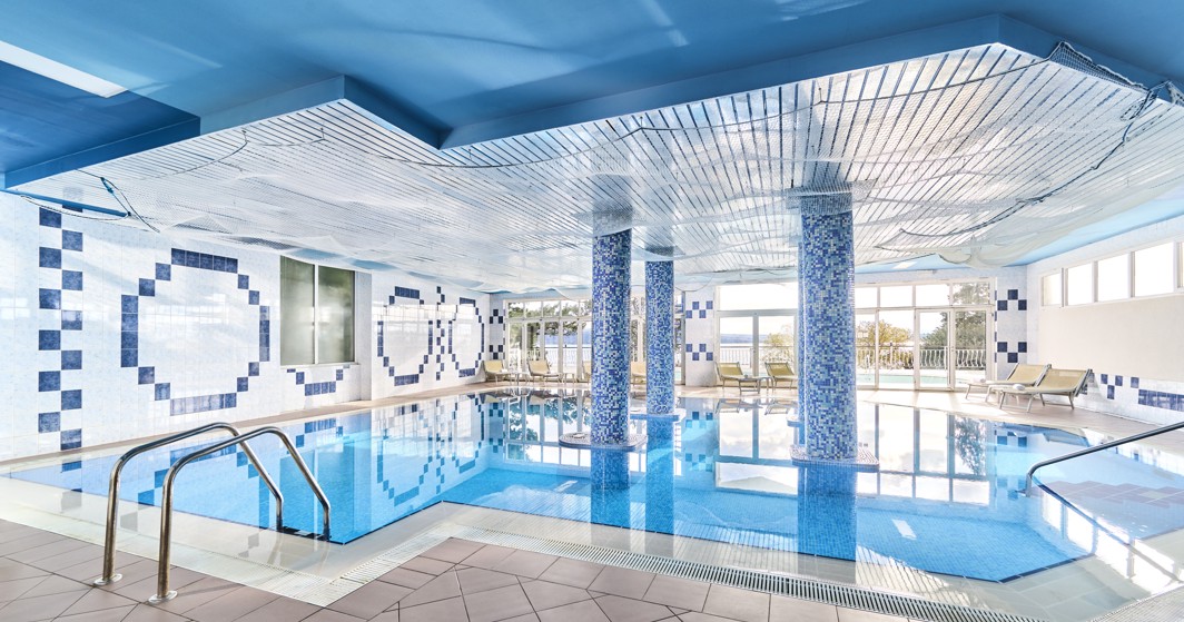 Unutarnji bazen u hotelu Mediteran Maradiso by Aminess s jarko plavim naglascima i opuštajućim prostorima za odmor.