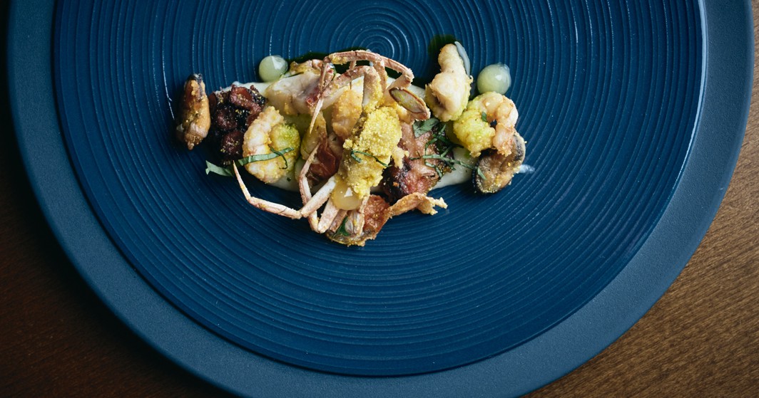 Delizie di pesce gourmet su un piatto blu.