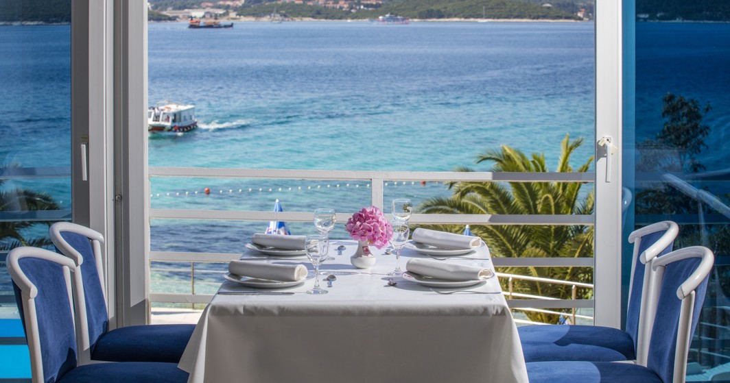 Ein Paar genießt ein romantisches Abendessen bei Sonnenuntergang auf der Terrasse des nahegelegenen Maradiso Orsan Hotels von Aminess mit Blick auf das Adriatische Meer.