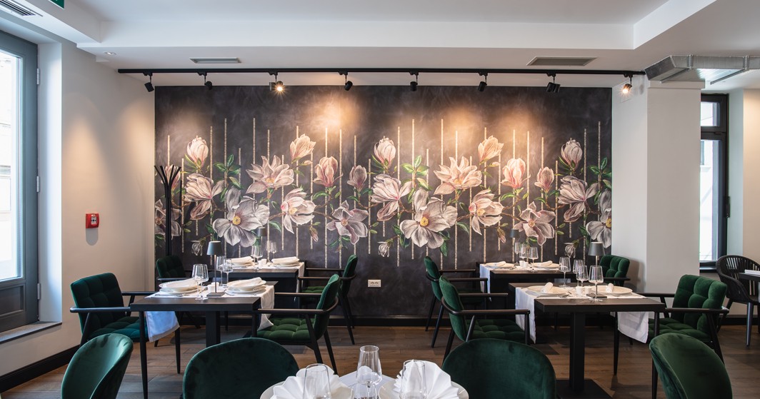 Hotel restaurant interior with floral wall and elegant dining tables