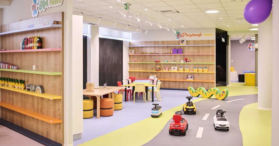 L'immagine mostra una sala giochi dell'hotel con varie attività e servizi per bambini.