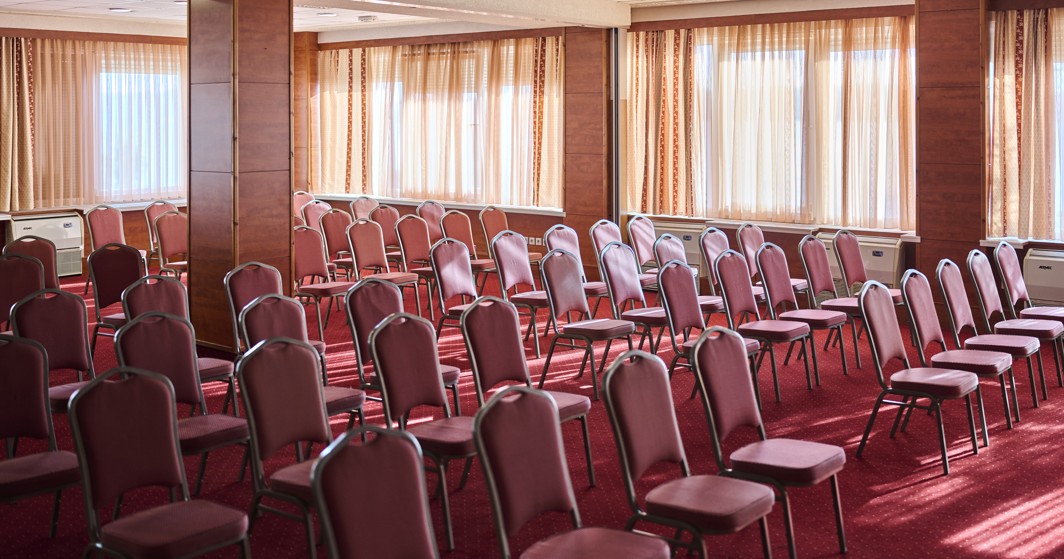 Kongresna dvorana u hotelu Mediteran Maradiso by Aminess s uredno posloženim stolicama.