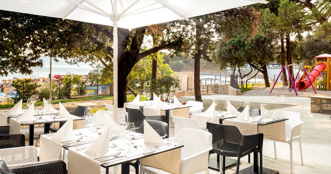 Aminess Vival Lišanj Family Hotel Außenrestaurant Terrasse mit schattigen Sitzplätzen, umgeben von Grün und einer familienfreundlichen Atmosphäre in Novi Vinodolski.