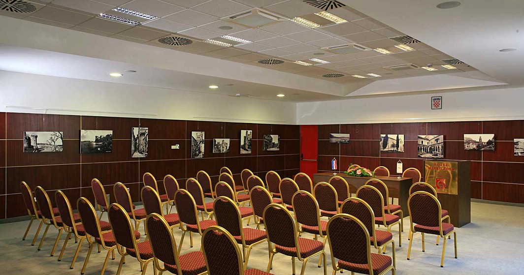 Prostrana kongresna dvorana s uredno posloženim stolicama i opremom za prezentacije, namijenjena korporativnim događanjima, sastancima i konferencijama u Maradiso Marko Polo by Aminess na Korčuli
