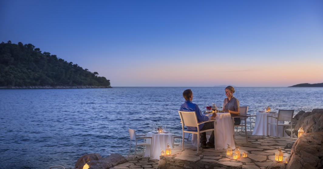 Par uživa u romantičnoj večeri na hotelskom balkonu, okružen elegantnim dekorom i zadivljujućim pogledom u Aminess Younique Lume Hotelu u Hrvatskoj.