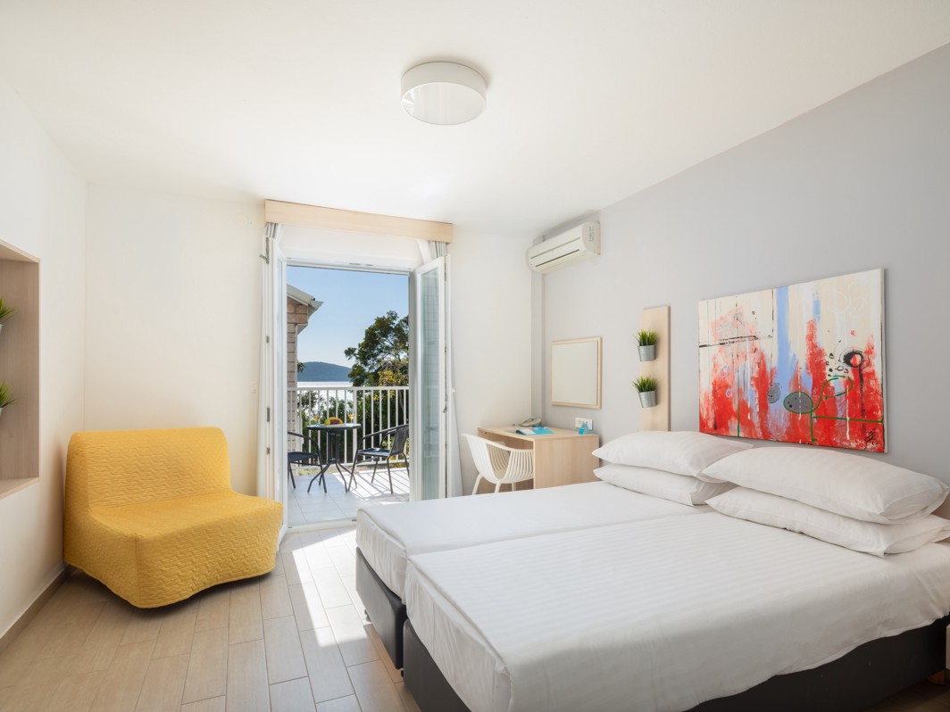 Ein helles und luftiges Zimmer im Aminess Maradiso Bellevue Village, mit einem komfortablen Bett und atemberaubendem Meerblick.