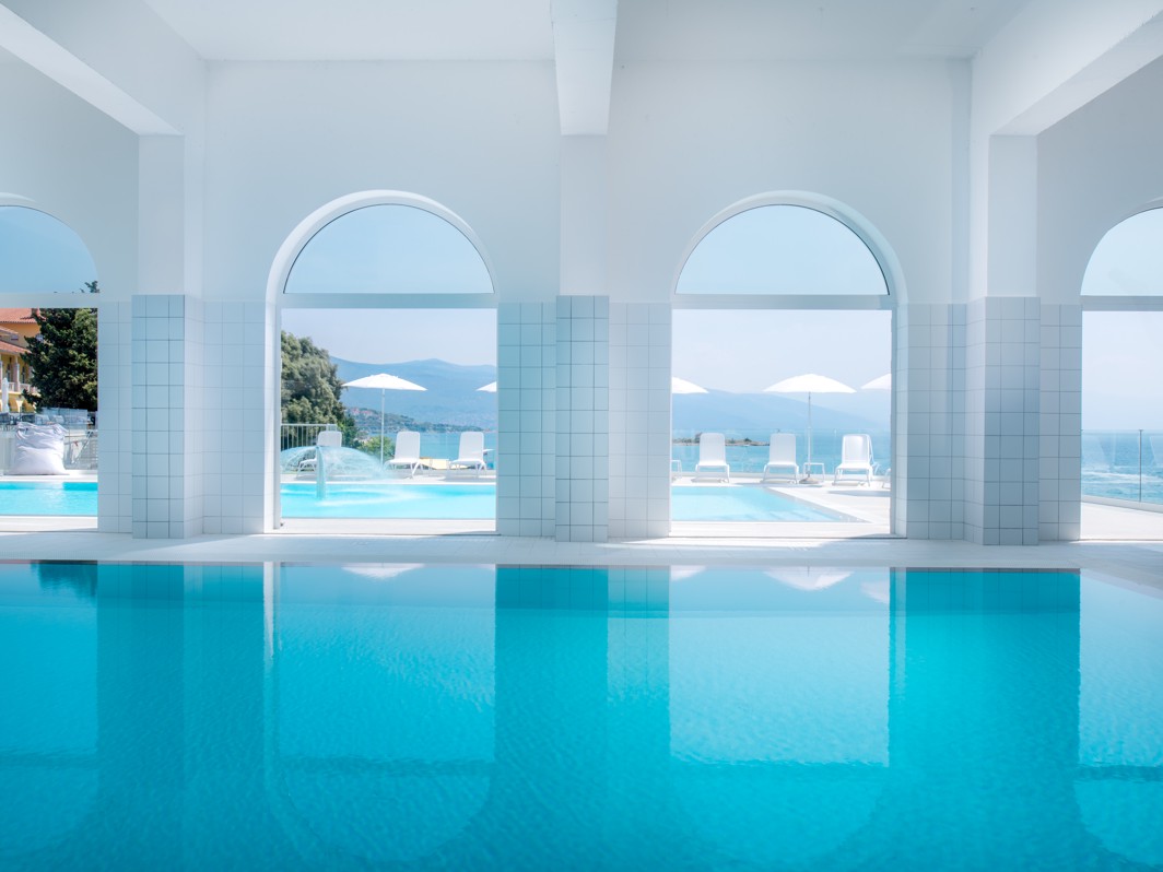 Indoor swimming pool with large windows and sea views at Aminess Vival Lišanj Family Hotel.