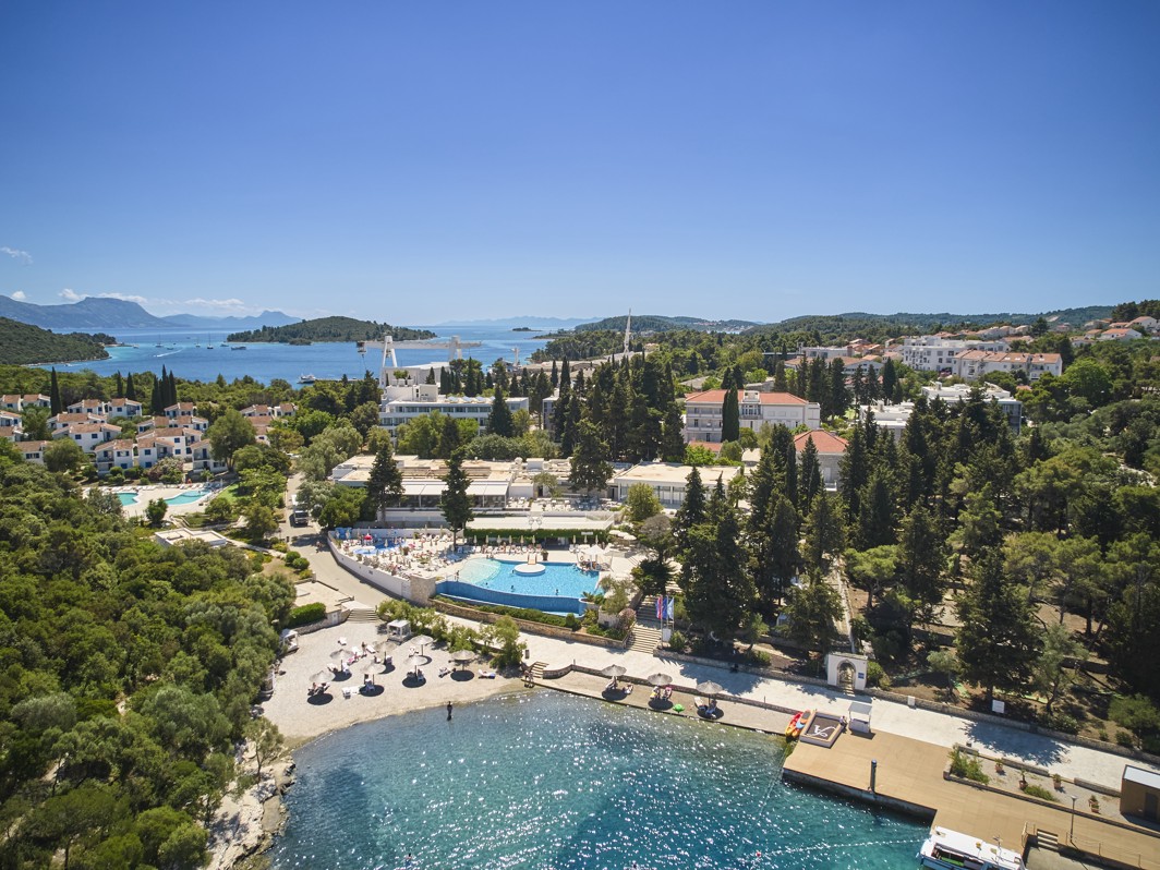 Exterior aerial view of Aminess Vival Port9 Resort, surrounded by greenery and the sea located in a bay on the island of Korcula.