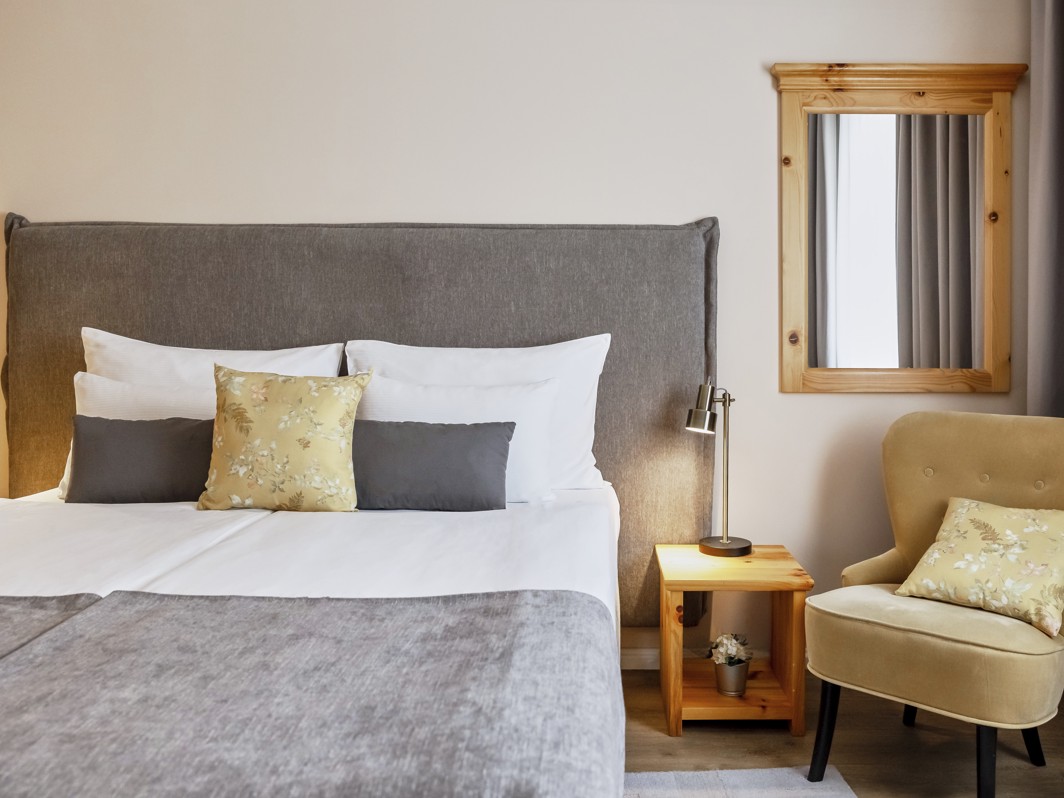 Schlafzimmer der Suite im Aminess Hotel Karlovac mit bequemem Bett und Sitzecke