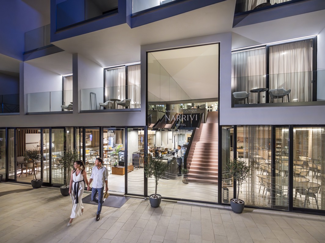 Night view of the modern exterior of Aminess Younique Narrivi Hotel.