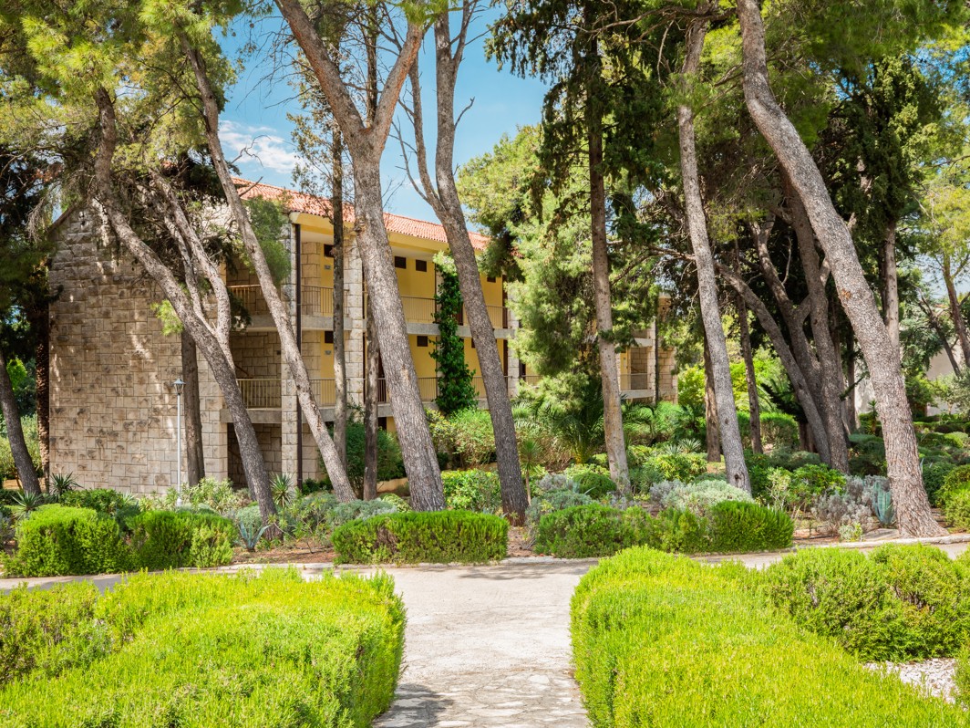 Vanjski pogled na Aminess Casa Velaris na Braču okruženu borovima i mediteranskim vrtom