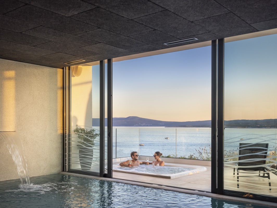 Couple relaxing in a jacuzzi with a sea view at the wellness center of Aminess Younique Narrivi Hotel in Crikvenica.