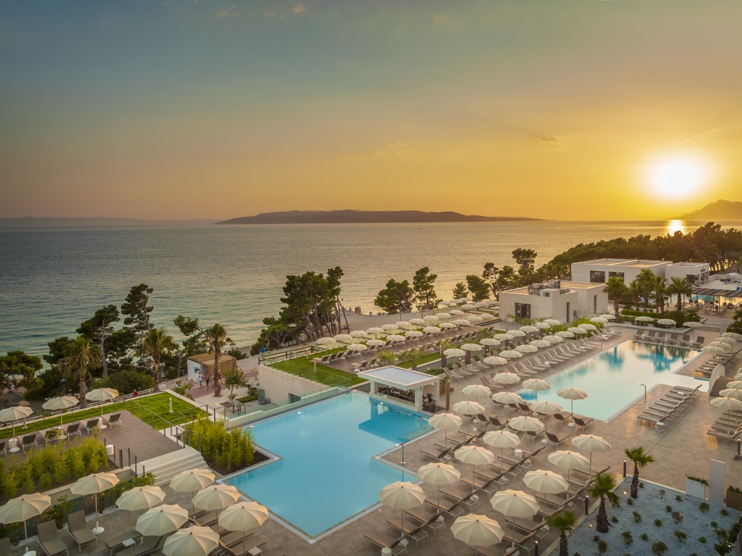 Beautifully arranged deck chairs, swimming pools, the sea and the sunset at Aminess Laurel Khalani Hotel in Makarska.