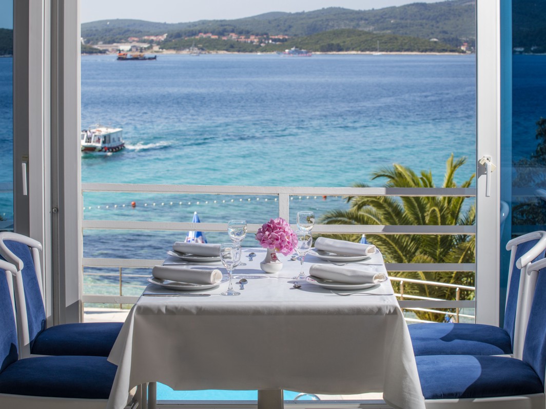 Una coppia che si gode un'esperienza culinaria romantica al tramonto sulla terrazza del vicino Maradiso Orsan Hotel by Aminess, con vista sul Mare Adriatico.