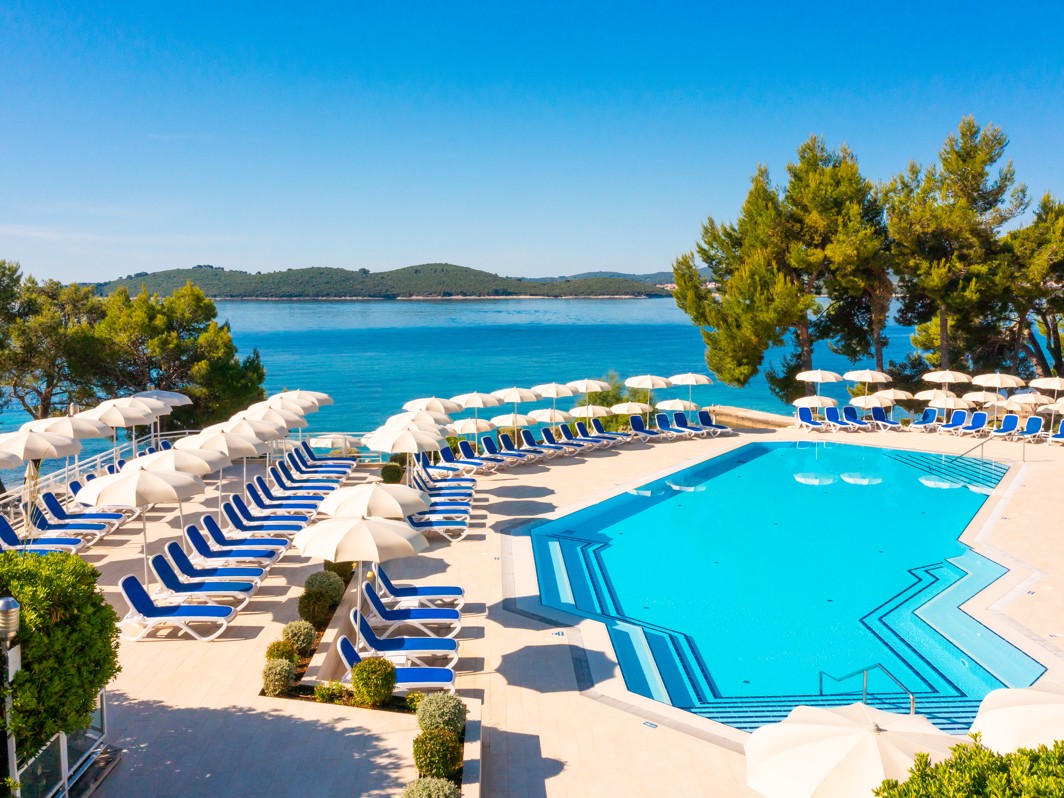 Stunning seaside view of the pool area surrounded by natural beauty at Aminess Vival Grand Azur Hotel.