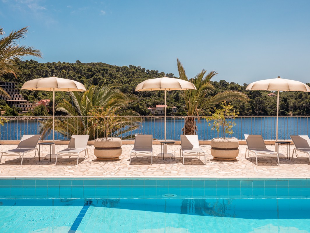 Relaxing by the pool in front of Aminess Younique Lume Hotel, the perfect spot to enjoy peace, comfort, and premium hotel service.