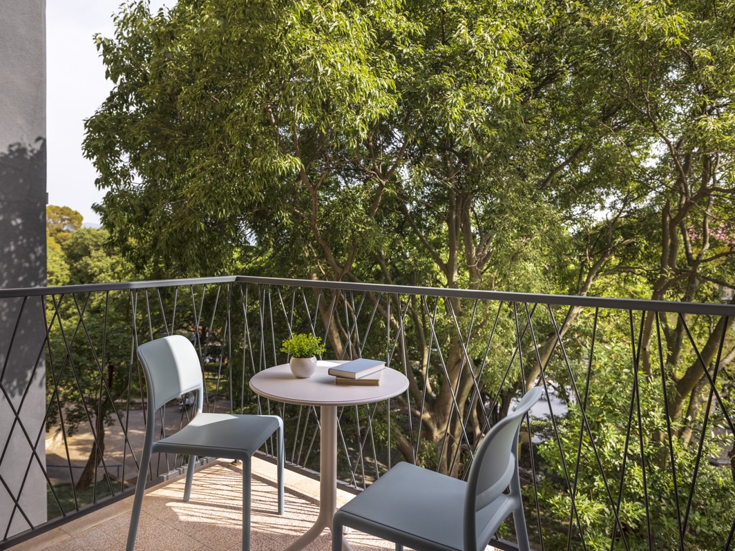 Balcony view at Aminess Vival Casa Lišanj with outdoor seating, surrounded by lush greenery in Novi Vinodolski.
