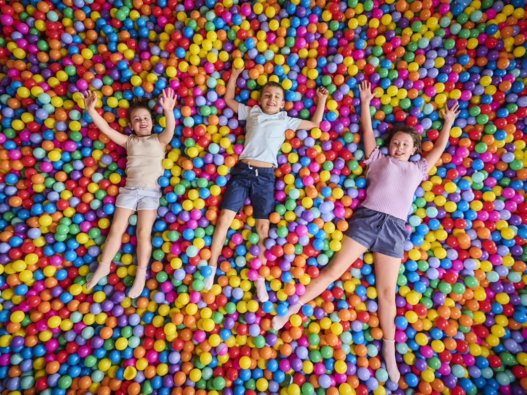 Bambini giocano e si sdraiano in una piscina di palline colorate nell area giochi