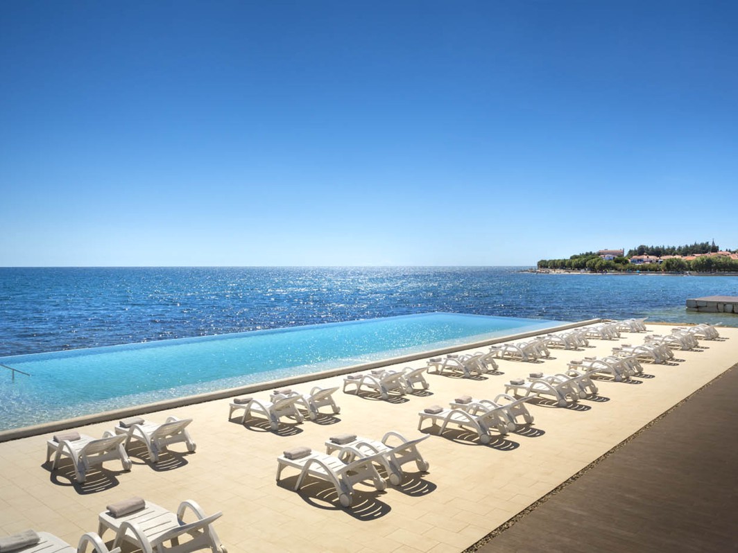 Postavljanje ležaljki kraj infinity bazena s pogledom na more i Novigrad.