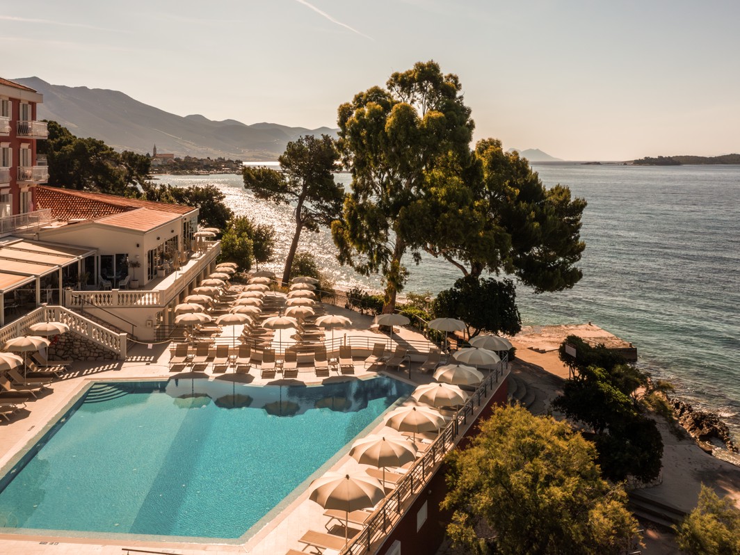 Sun bed are by the hotel pool, pine trees and a beach near Aminess Maradiso Bellevue Village.