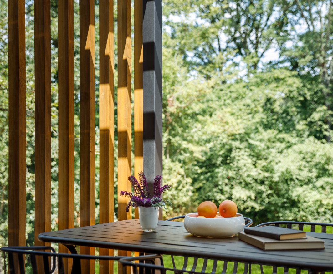 Accogliente balcone presso Aminess Younique Gaia Green Villas con un design moderno, con vista su una lussureggiante vegetazione e dotato di un piccolo tavolo con accenti decorativi.