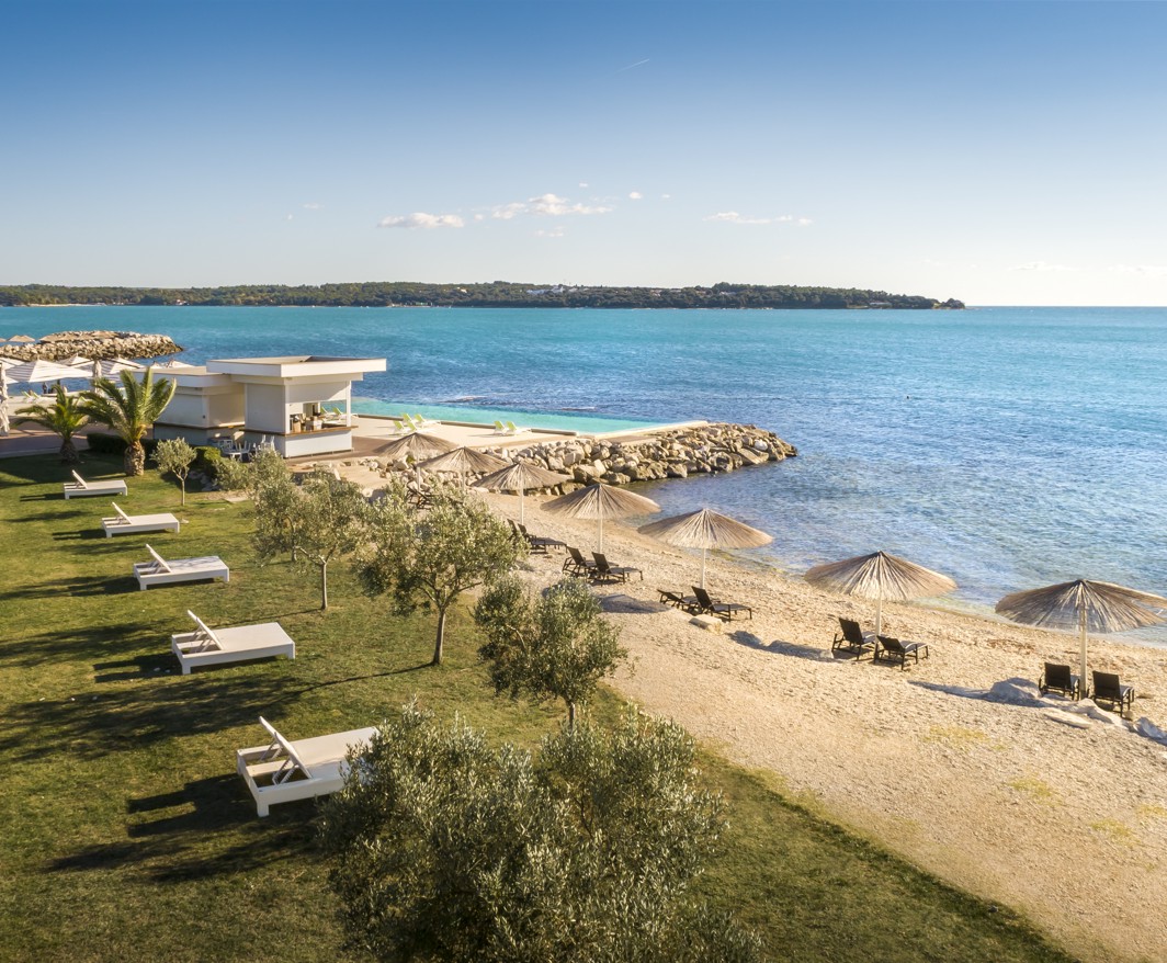 Vista aerea del bar sulla spiaggia a Punto Mare in riva al mare, con lettini prendisole.