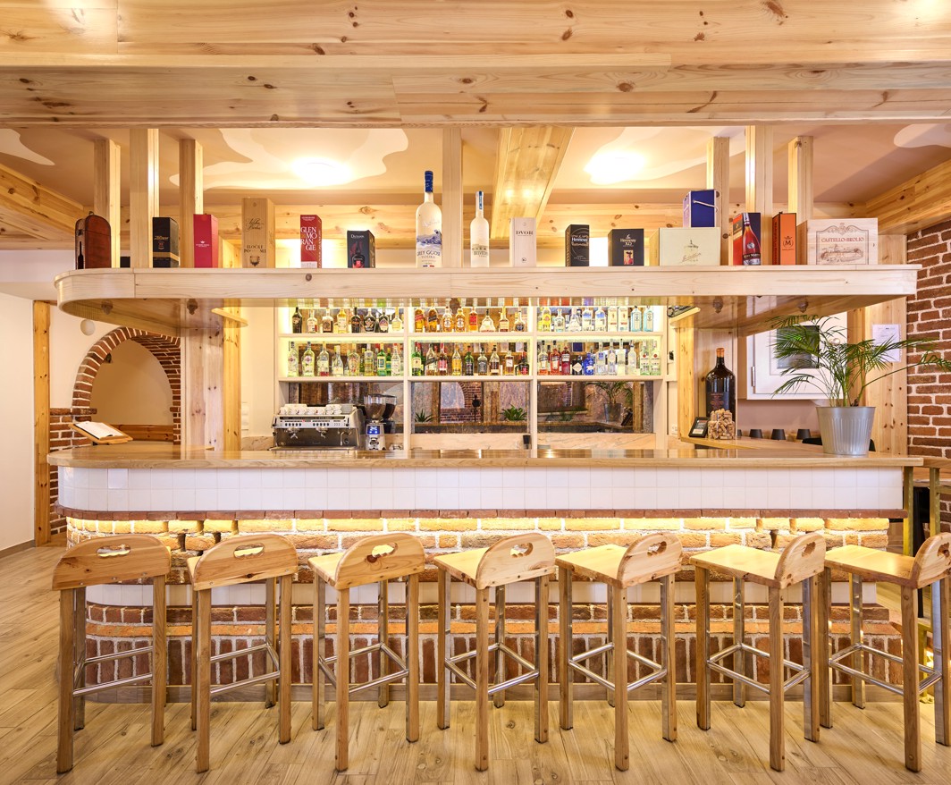 Bar dell hotel Aminess a Karlovac con dettagli in legno e selezione di bevande