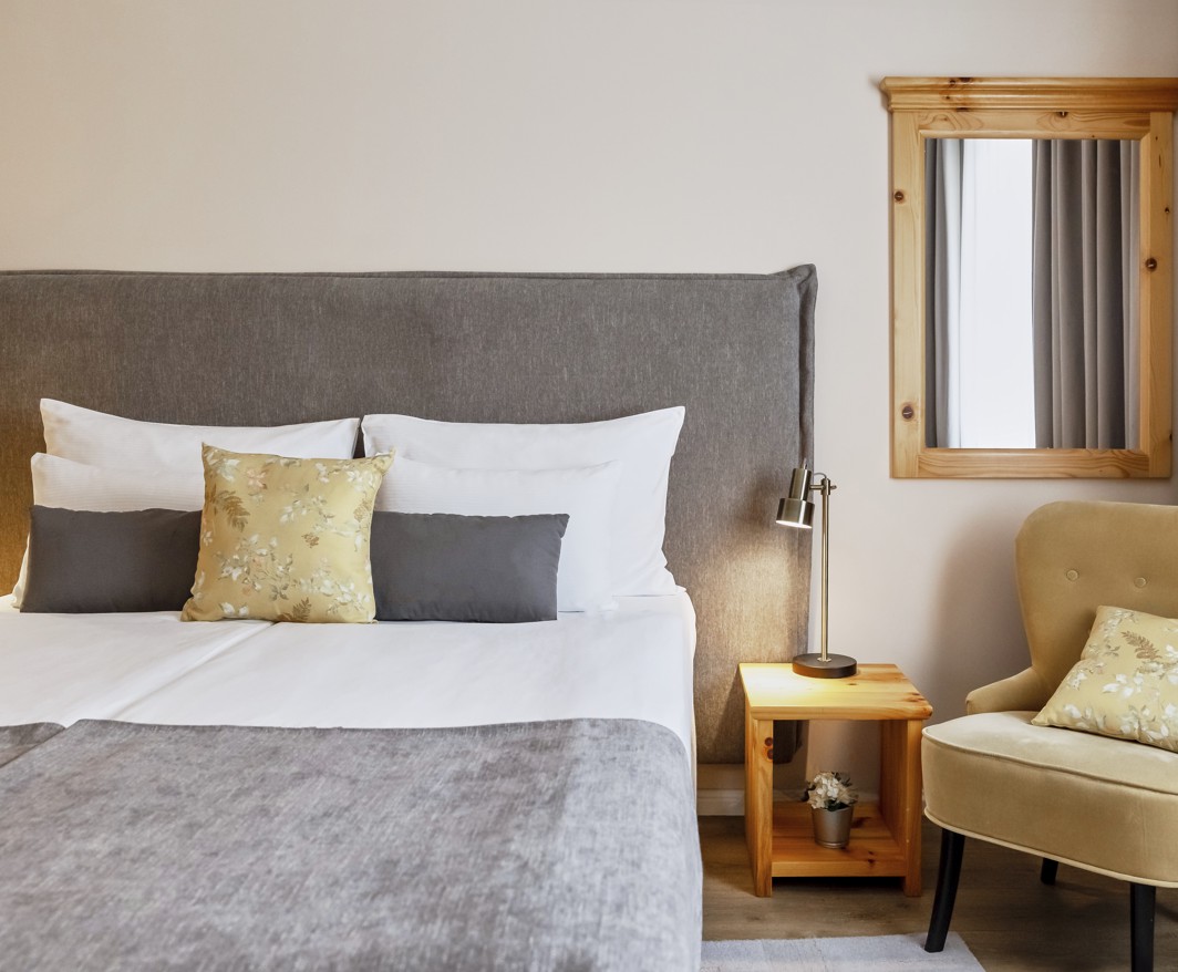 Camera da letto della suite dell hotel Aminess Karlovac con letto comodo e area salotto