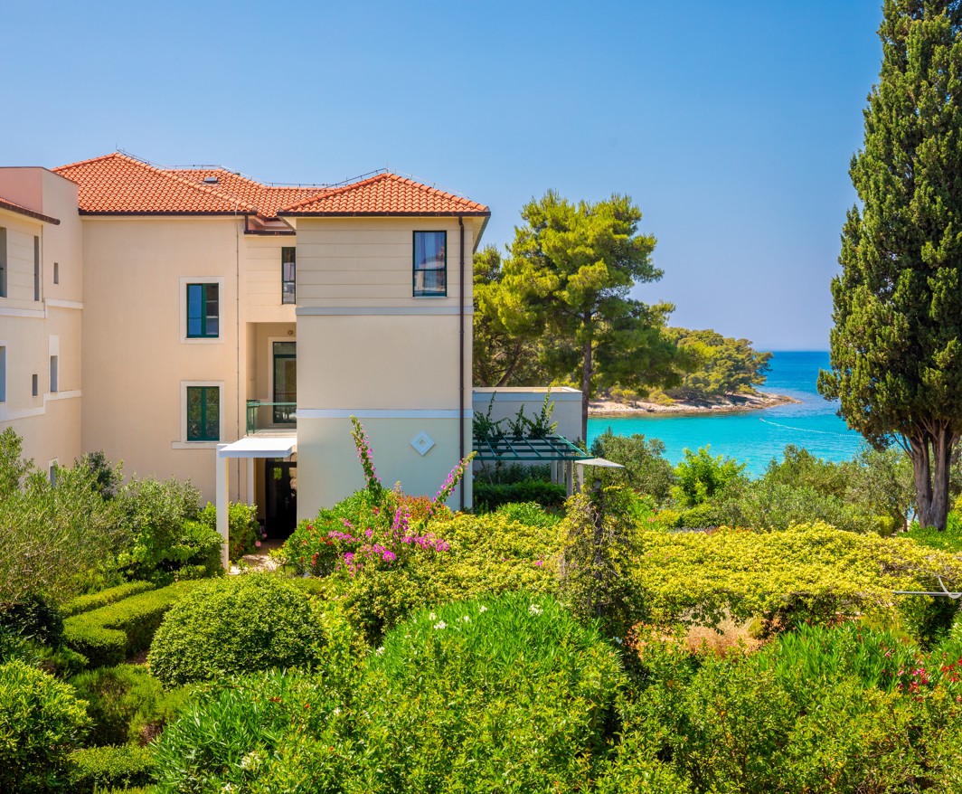 Exterior of Aminess Vival Velaris Resort on Brač island with a view of the Adriatic Sea and lush Mediterranean greenery