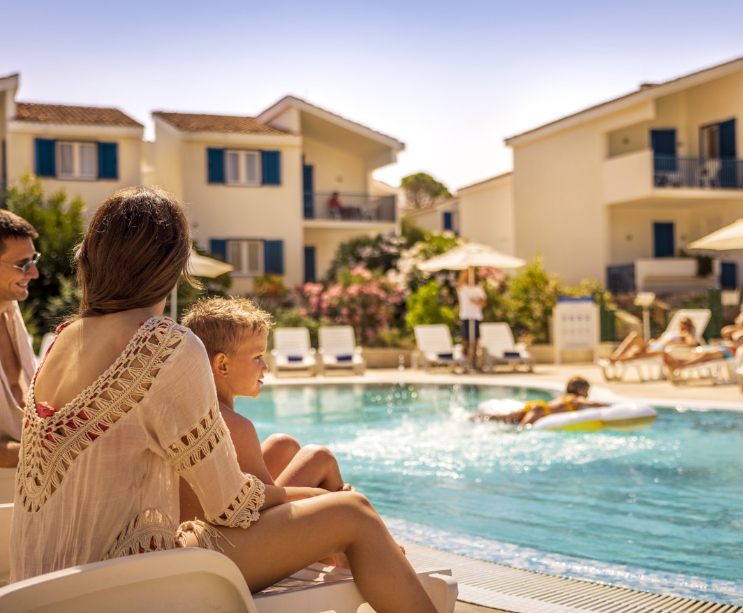 Family relaxing by the the pool within resort near Aminess Port9 Residence.