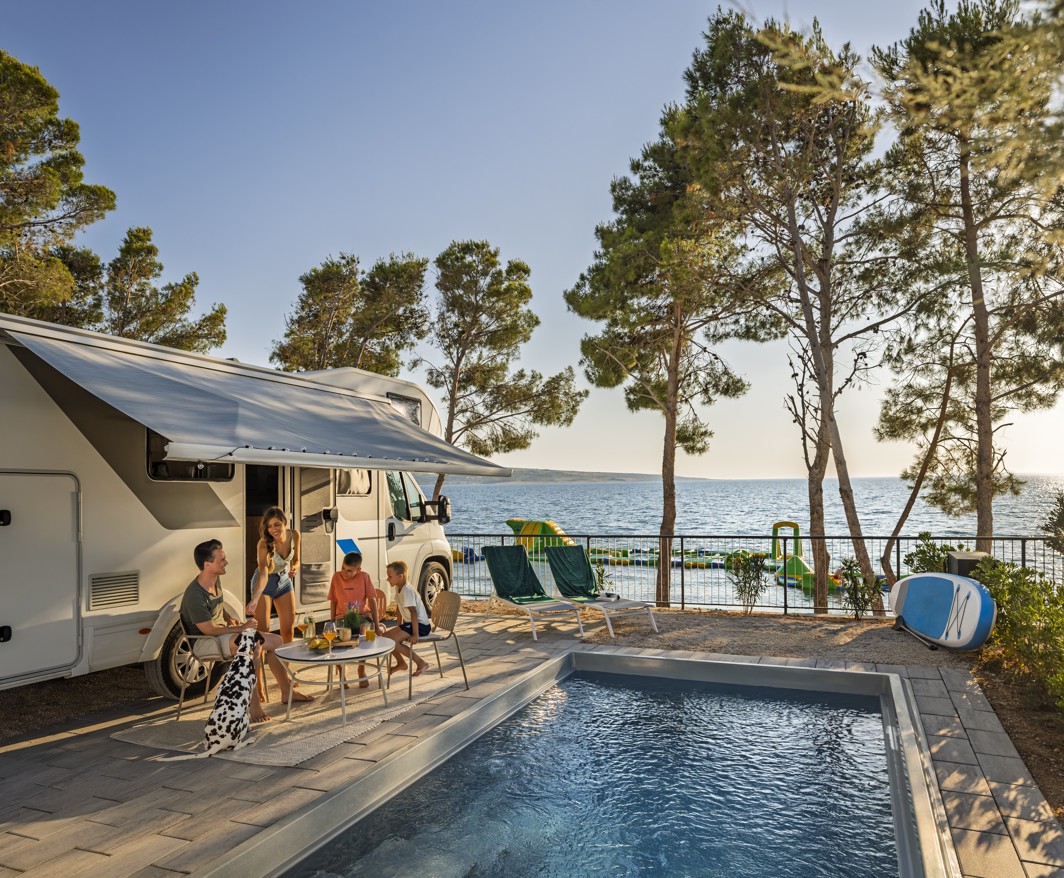 Družina uživa ob avtodomu in zasebnem bazenu z razgledom na morje v Avalona Resortu