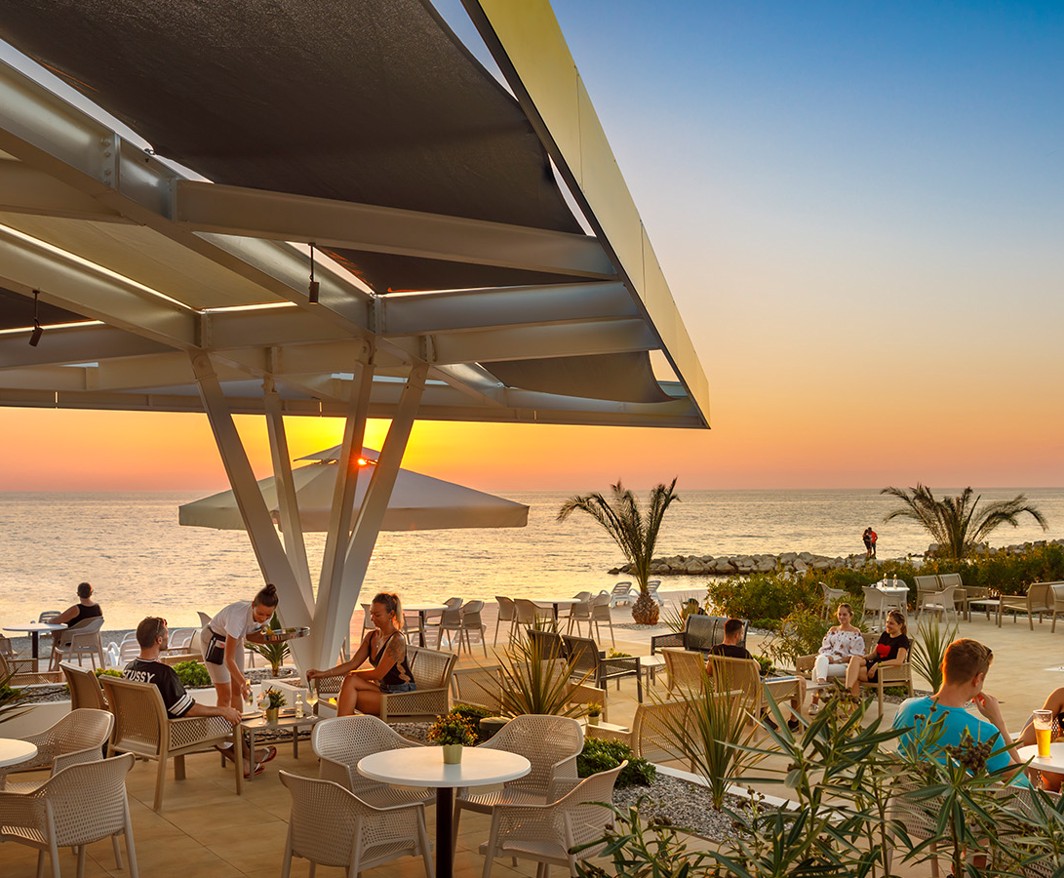 Eine Strandbar mit dem Sonnenuntergang im Hintergrund im Aminess Planet Camping Maravea Resort, Novigrad Kroatien