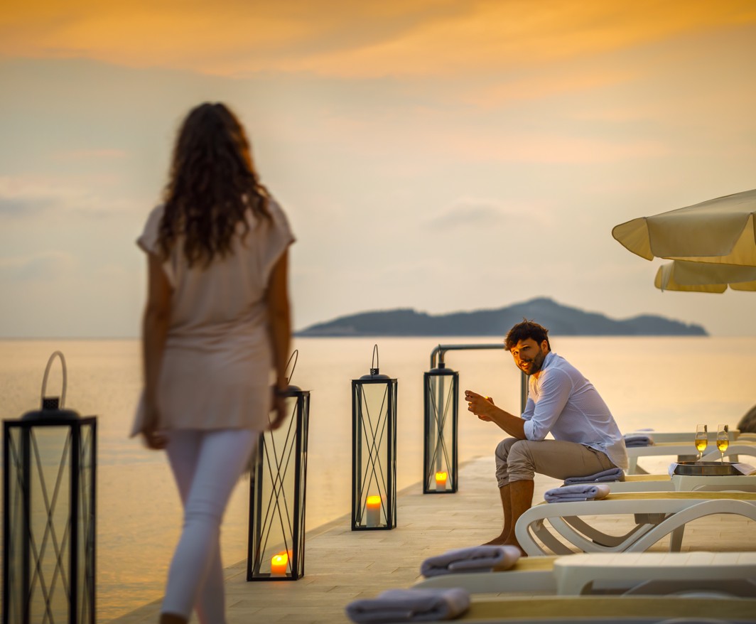 Par uživa u zalasku sunca na plaži u Aminess Younique Lume Hotelu u Hrvatskoj.