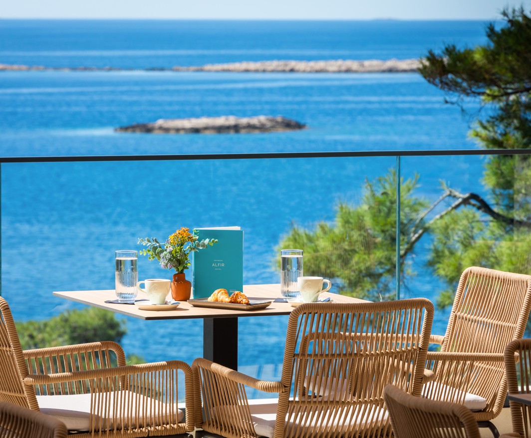 Ontbijttafel op het barterras van Aminess Alfir Hotel met uitzicht op zee.