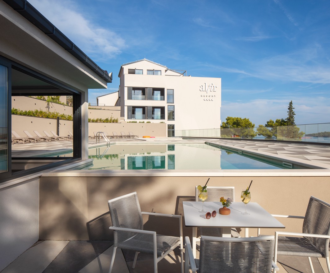 Terras van de poolbar in het Aminess Alfir Resort aan het zwembad met modern meubilair, verfrissende drankjes en uitzicht op het resort en de zee