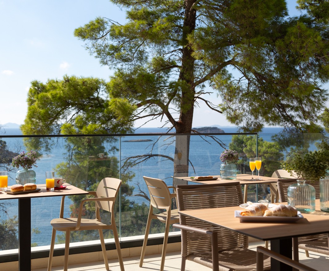 Restaurantterras van Aminess Alfir Resort met ontbijttafels en uitzicht op zee en pijnbomen