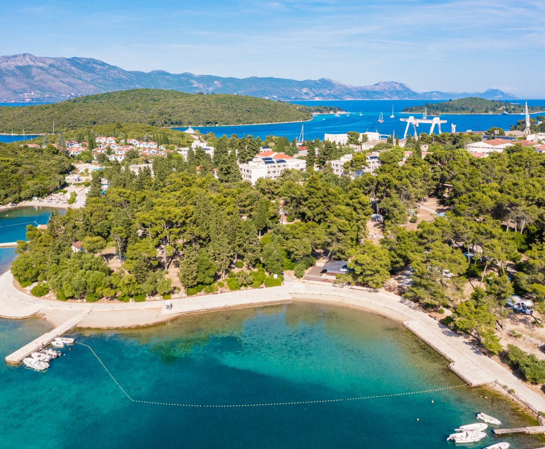 Panorama Aminess Port9 Planet Camping Resorta okružena plažom i ispunjena drvećem.