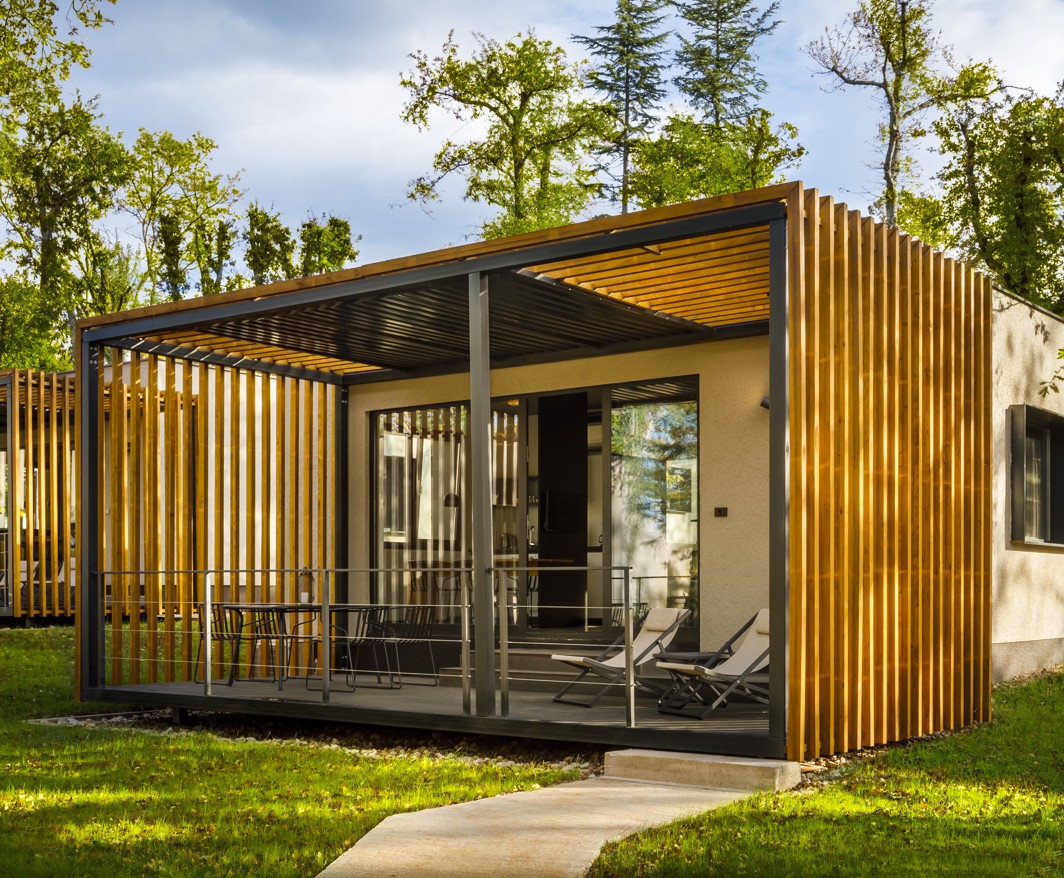 Vista esterna di Aminess Younique Gaia Green Villas circondate da alberi, che mette in mostra un'architettura moderna e un'integrazione naturale.