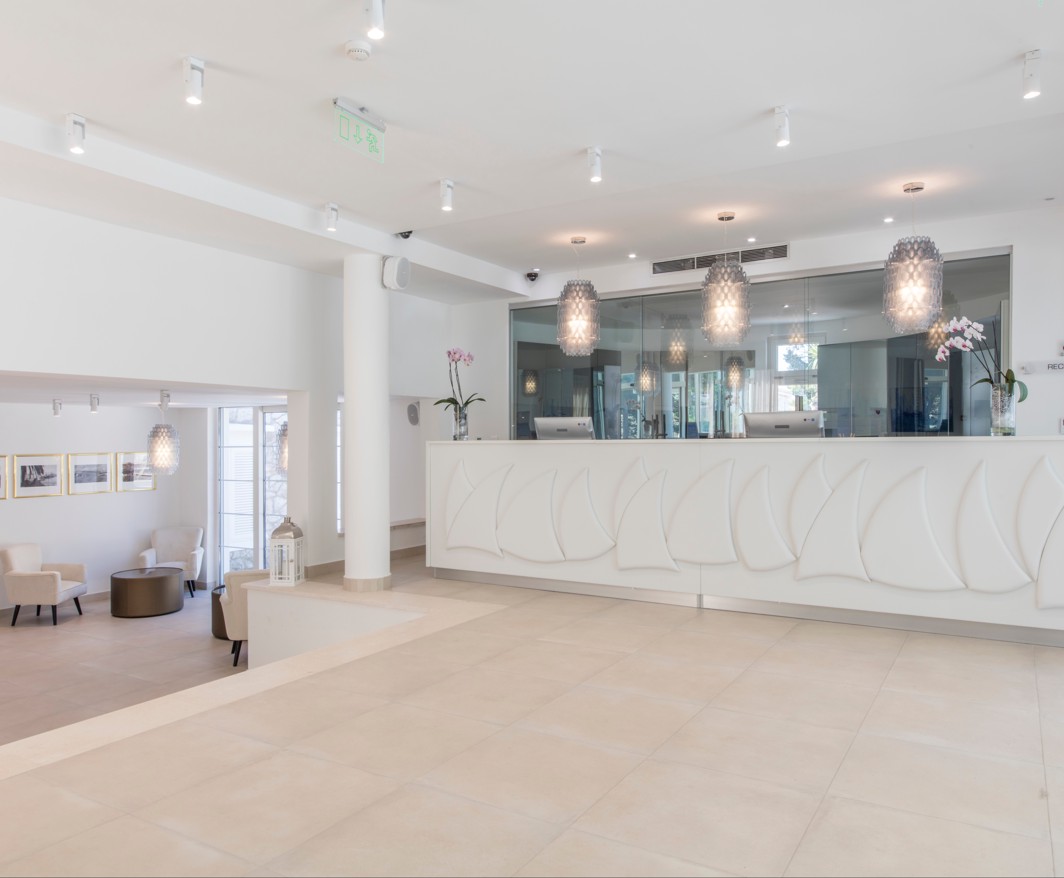 Moderne Rezeptionsbereich im Hotel in der Nähe von Aminess Maradiso Casa Bellevue in Orebic, mit schickem weißen Dekor, heller Beleuchtung und einem geräumigen Layout.