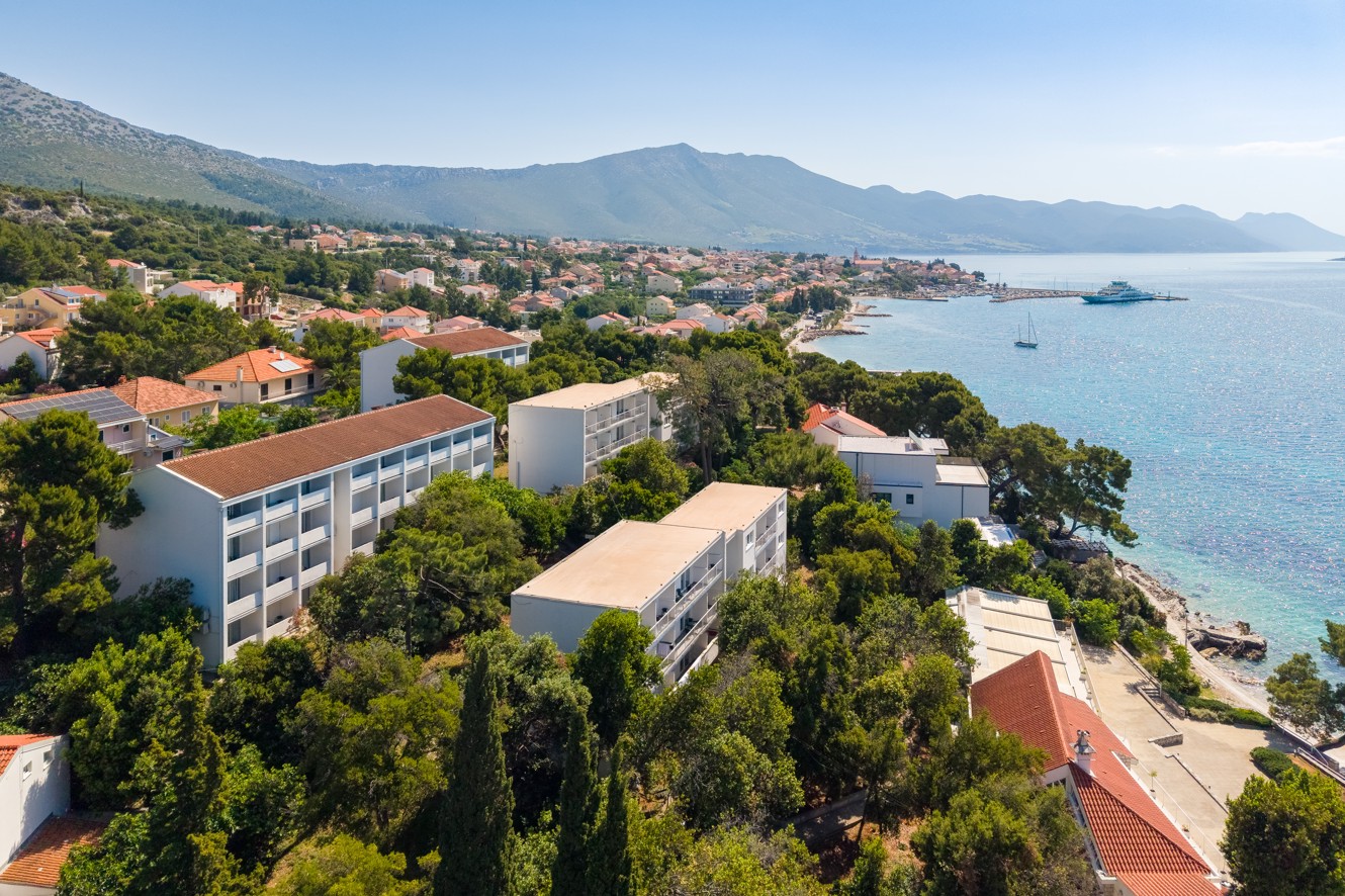 Aerial view of Bellevue Maradiso Casa by Aminess by the coast and mountains.